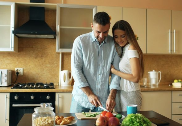 Happy young couple in the kitchen. Handsome man meet his girlfriend early morning at home